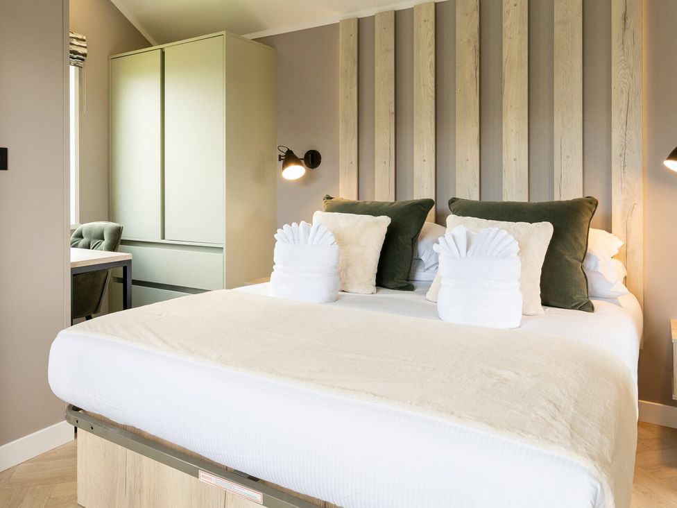 A bedroom with a bed and wardrobe at The Oasis in Great Ayton