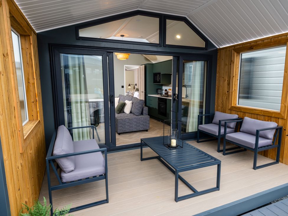 An outdoor area with seating and a view of the living room at The Oasis in Great Ayton