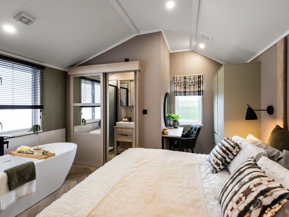A bedroom with a bathtub and vanity at The Oasis in Great Ayton