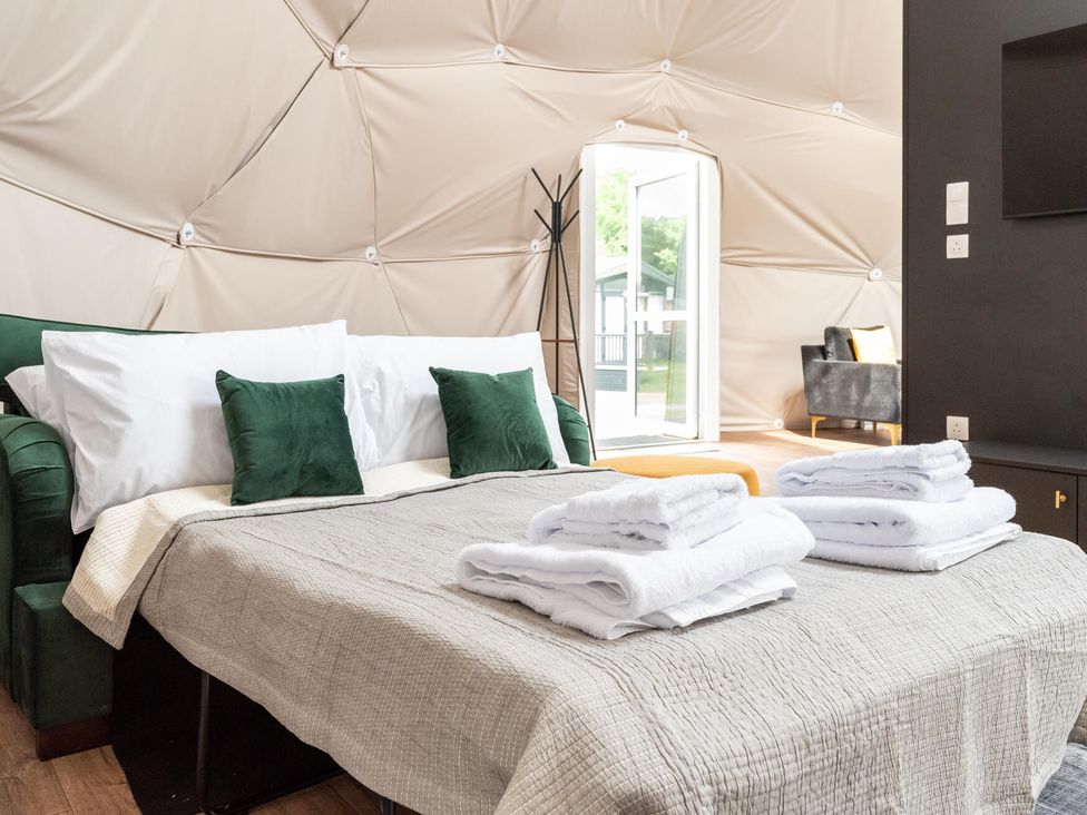 A bedroom with a bed and sofa at The Dome in Great Ayton