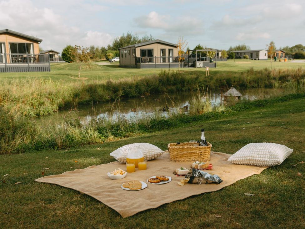 A picnic setup with food and drinks near a river at The Dome in Great Ayton