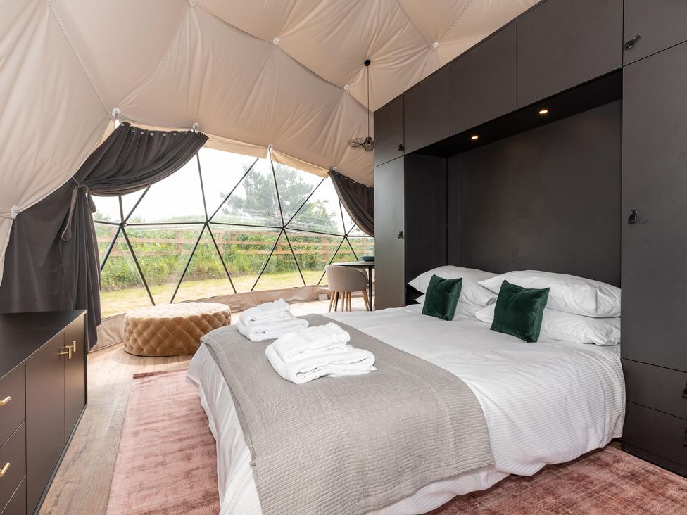 A bedroom with a bed and windows at The Dome (Pet) Great Ayton