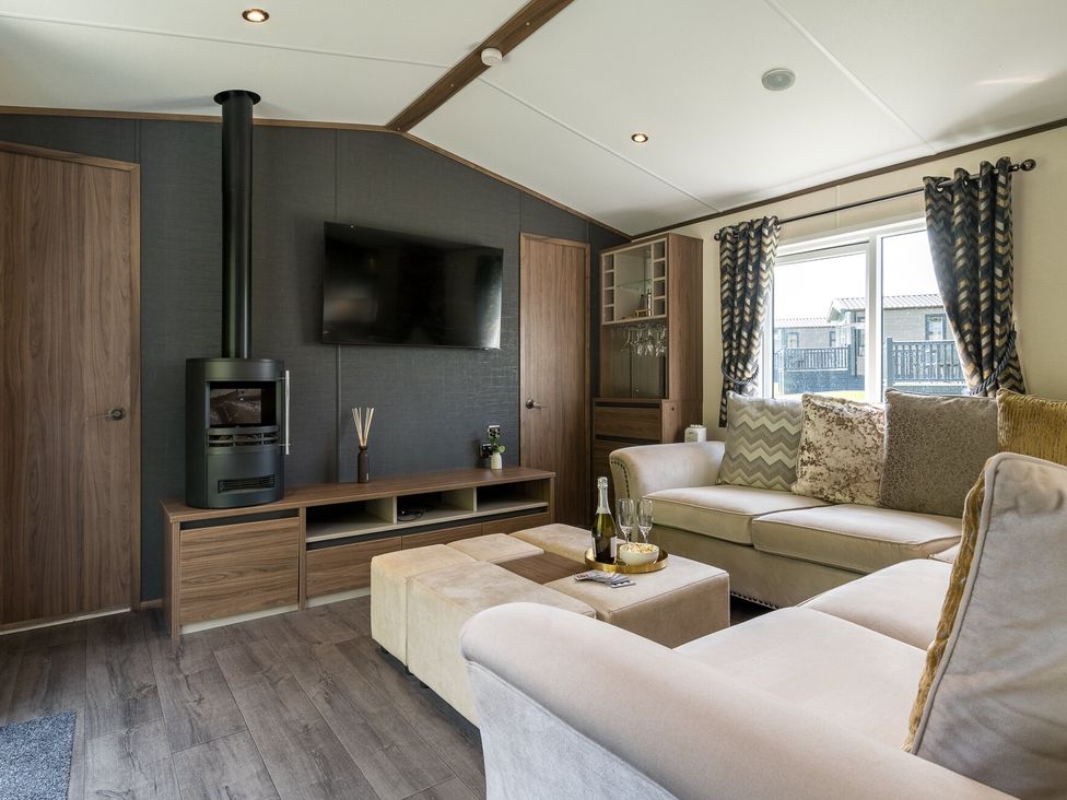 A living room with a sofa and a TV at The Woods in Great Ayton