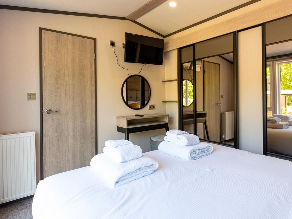 A bedroom with a bed and towels on the bedding at The Woods in Great Ayton