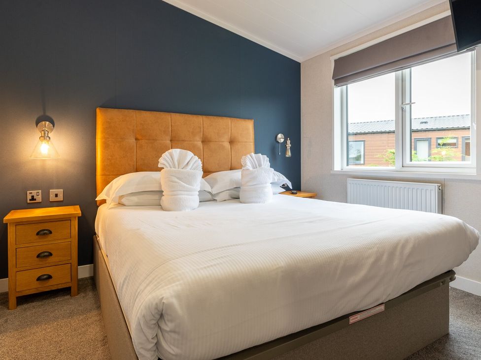 A bedroom with a large bed and a nightstand at Rosedale in Great Ayton