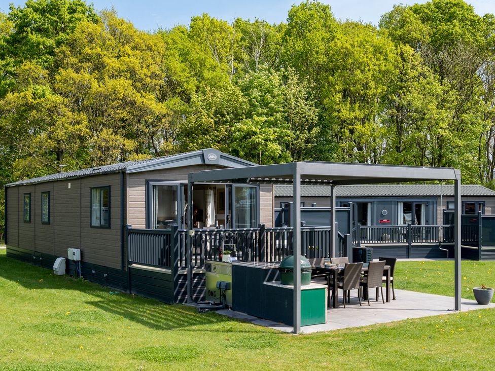 A mobile home with a deck and outdoor seating at Leven (Pet) Great Ayton