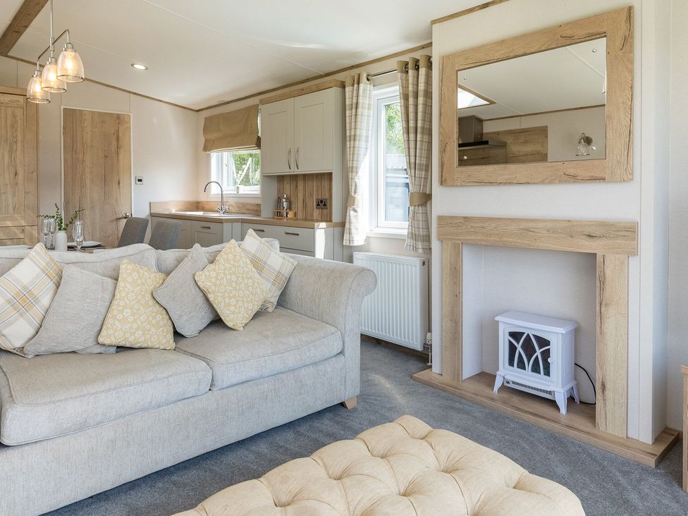 A living room with a sofa and kitchen units at Leven (Pet) Great Ayton