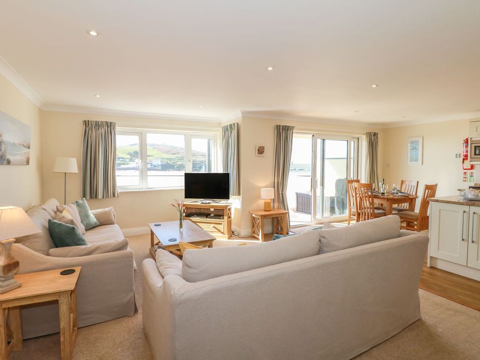 A living room with a television and dining area at 2 Burgh Island Causeway in Kingsbridge