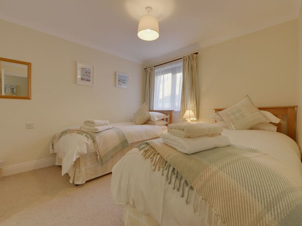 A bedroom with twin beds and a bedside lamp at 2 Burgh Island Causeway Kingsbridge