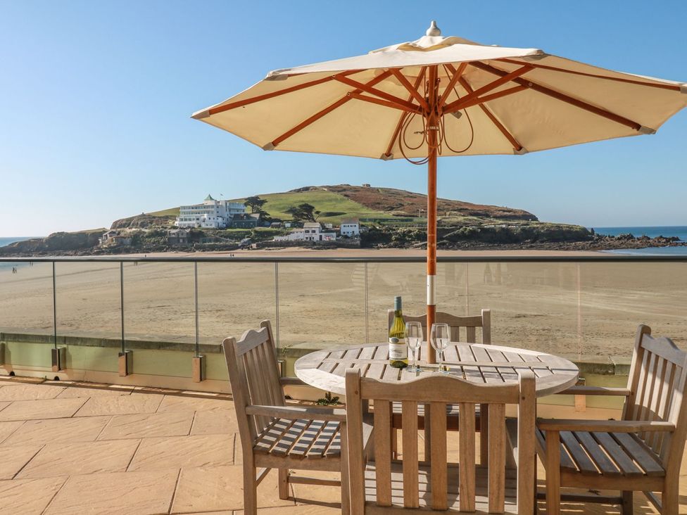 An outdoor dining area with a table and umbrella at 2 Burgh Island Causeway in Kingsbridge
