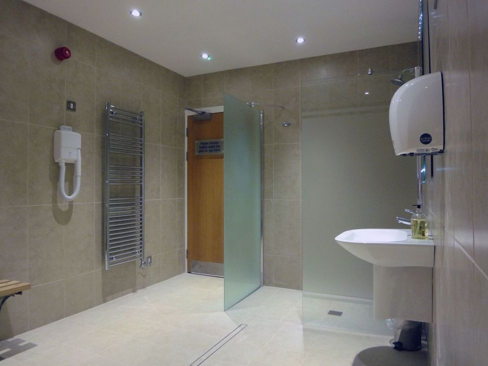 A bathroom featuring a sink and glass door at 2 Burgh Island Causeway in Kingsbridge