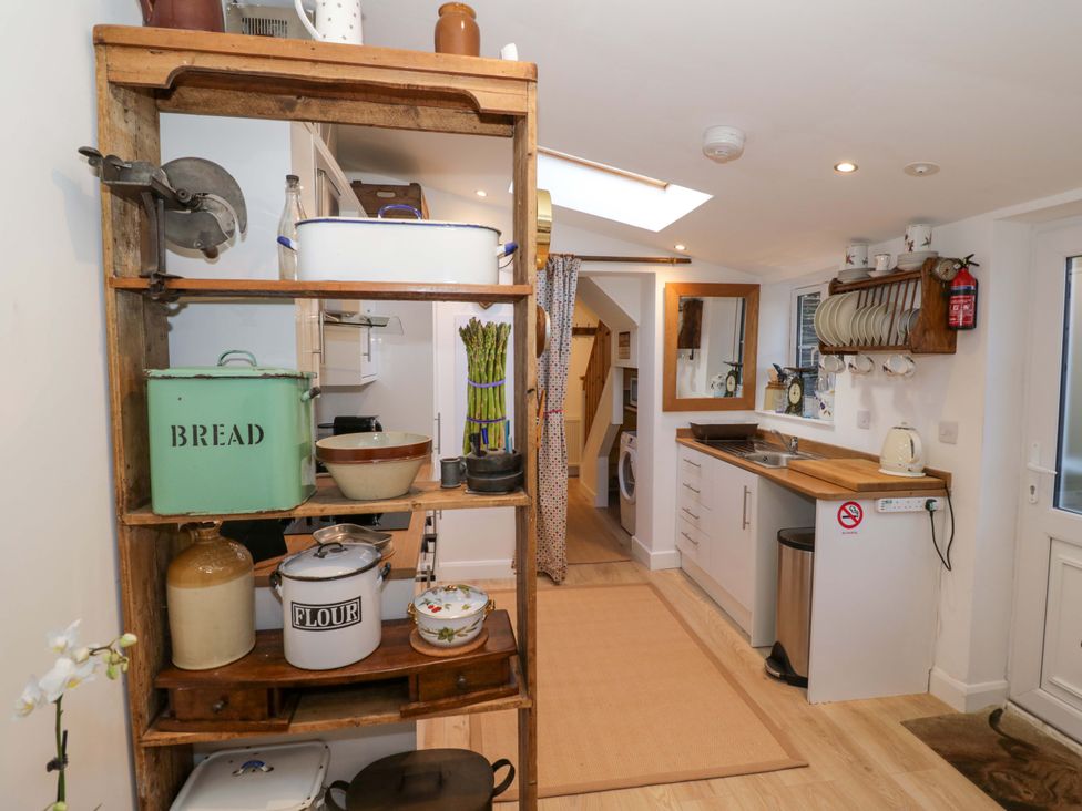 A kitchen with shelves and storage containers at Flat 4 in Evesham