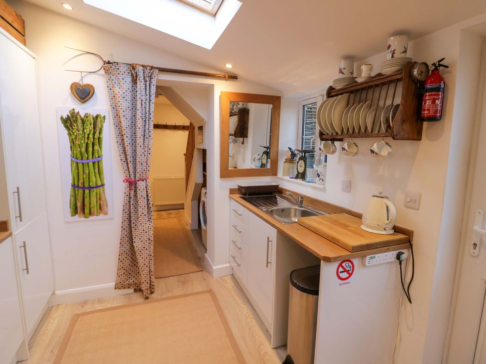 A kitchen with a sink and cutting board at Flat 4 in Evesham