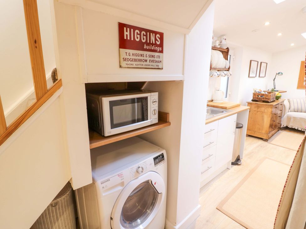 A kitchen with a microwave and washing machine at Flat 4 in Evesham