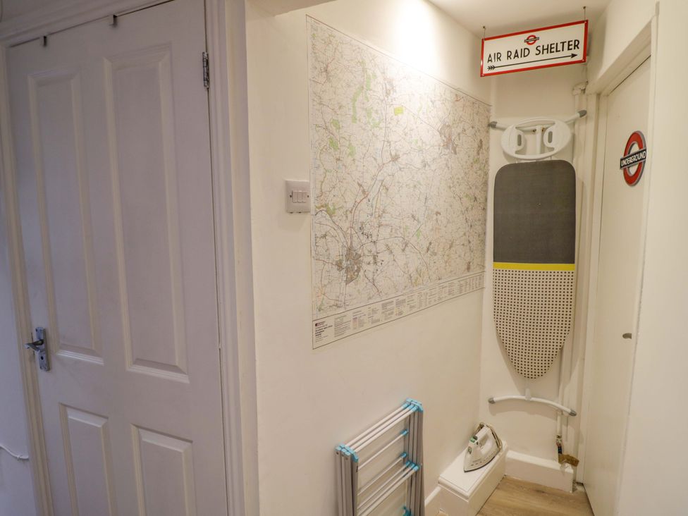 A hallway with a map and ironing board at Flat 4 in Evesham