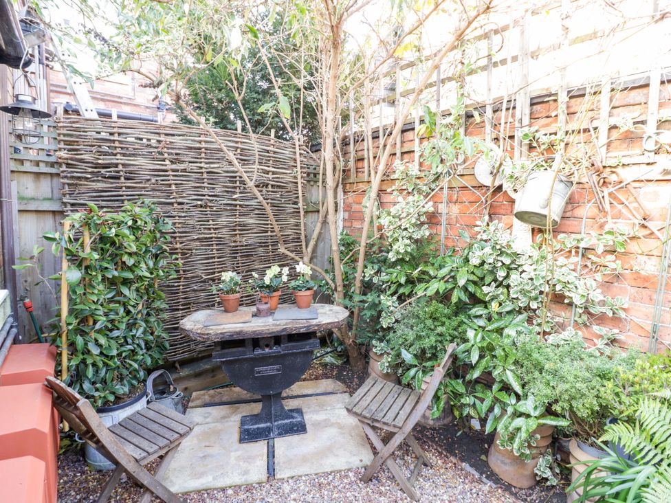 A garden with a table and chairs surrounded by plants at Flat 4 in Evesham