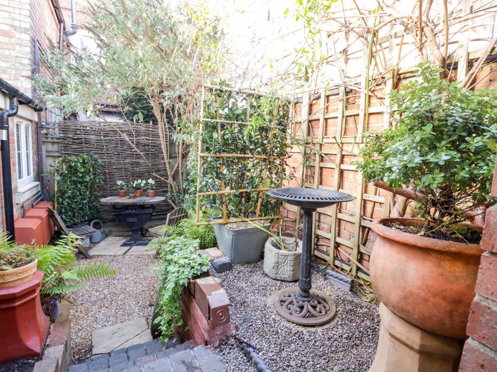 A garden with planters and a table at Flat 4 in Evesham