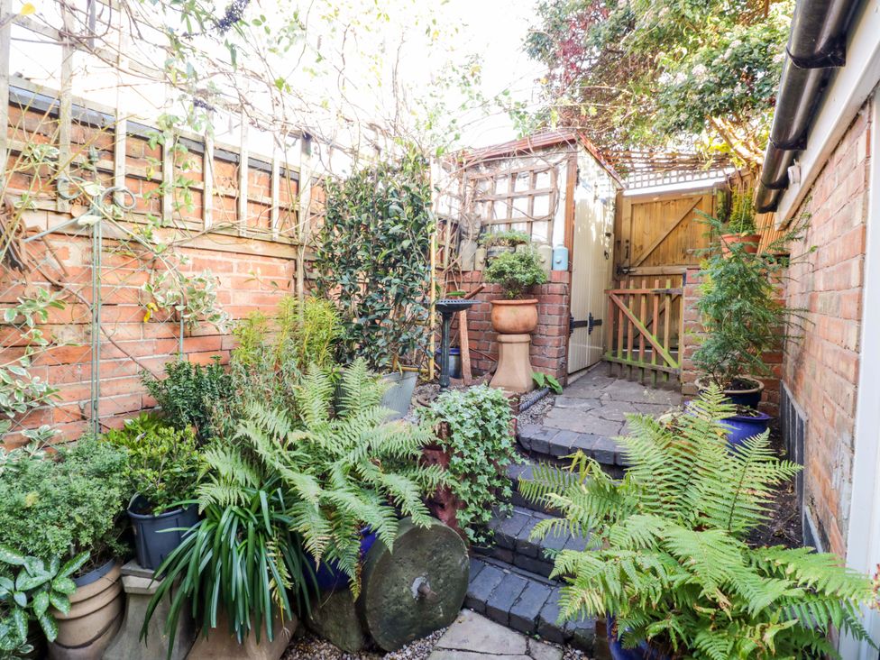 A garden with plants and a garden gate at Flat 4 in Evesham