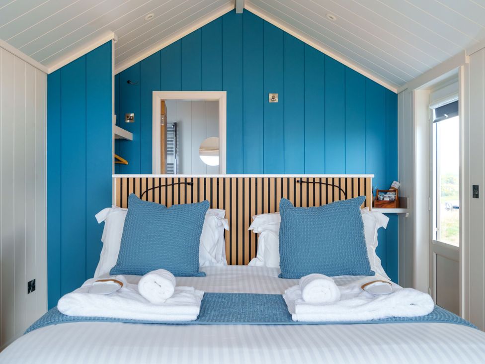 A bedroom with a bed and towels at The Grays in North Berwick