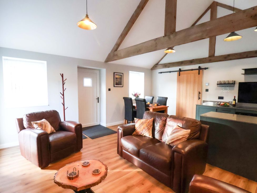 A living room with a sofa and dining area at The Homestead in Moorsholm