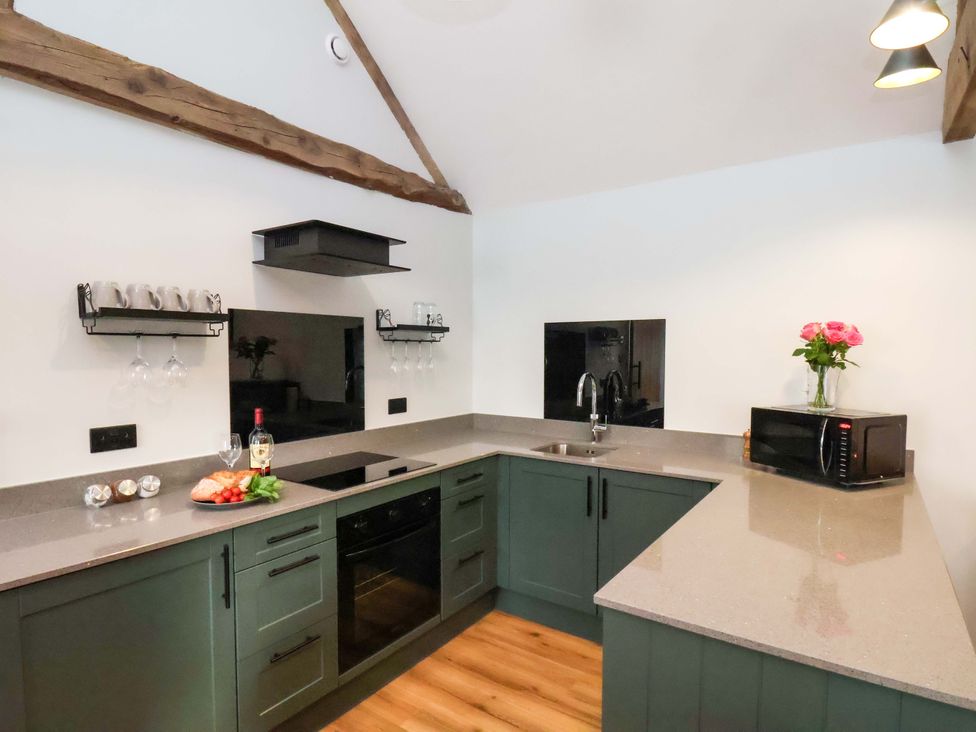 A kitchen with dark cabinets and appliances at The Homestead in Moorsholm
