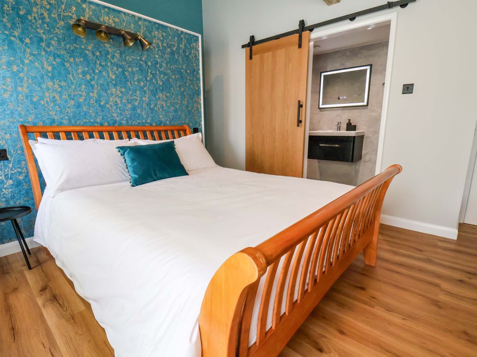 A bedroom with a bed and a bathroom door at The Homestead in Moorsholm