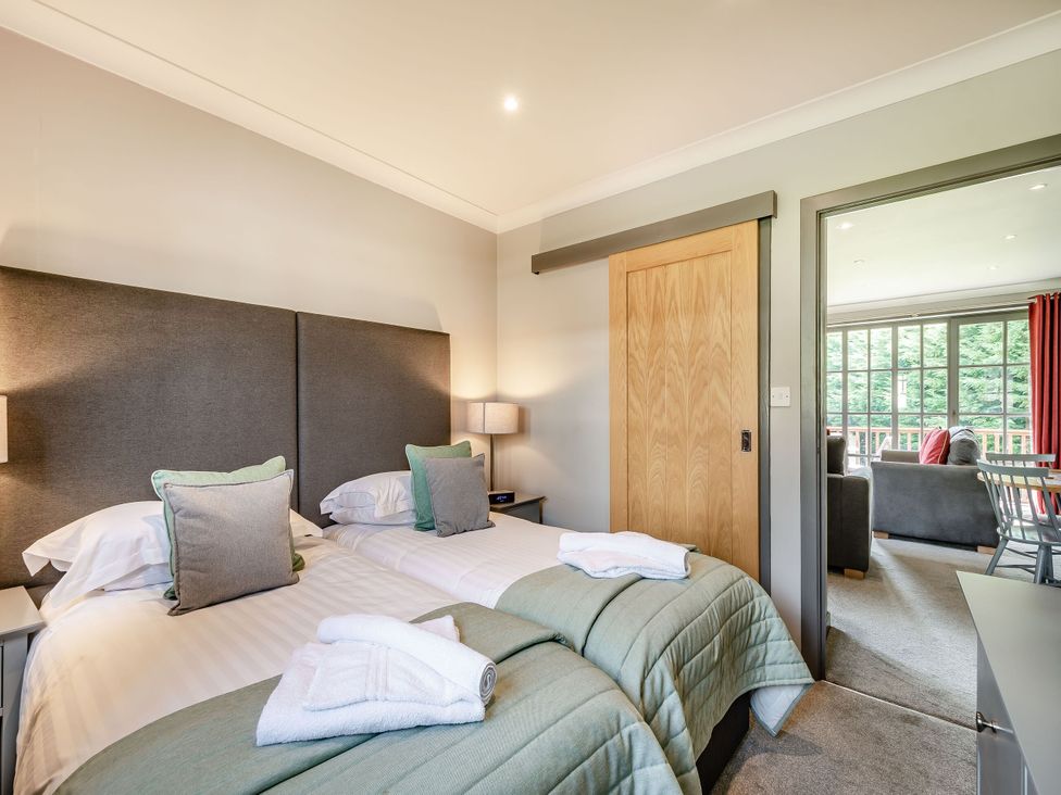 A bedroom with twin beds and a door leading to another room at Bargany (Pet) in Dailly