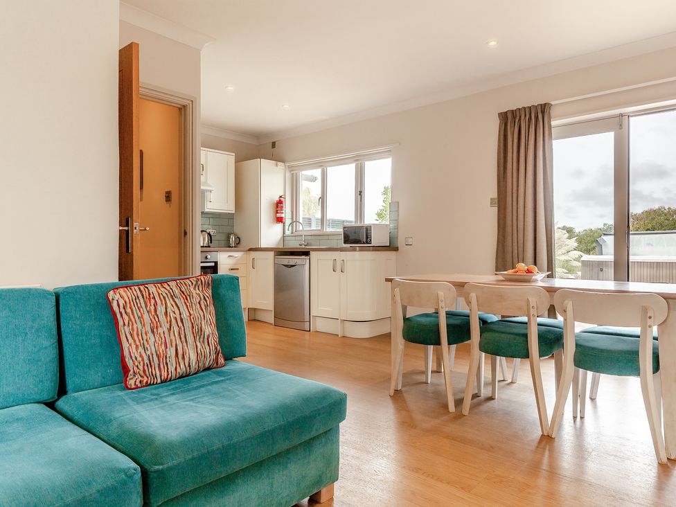 A kitchen with a sofa and dining table at 4C2 Summerleaze Garden Cottage 2 Spa in Bude