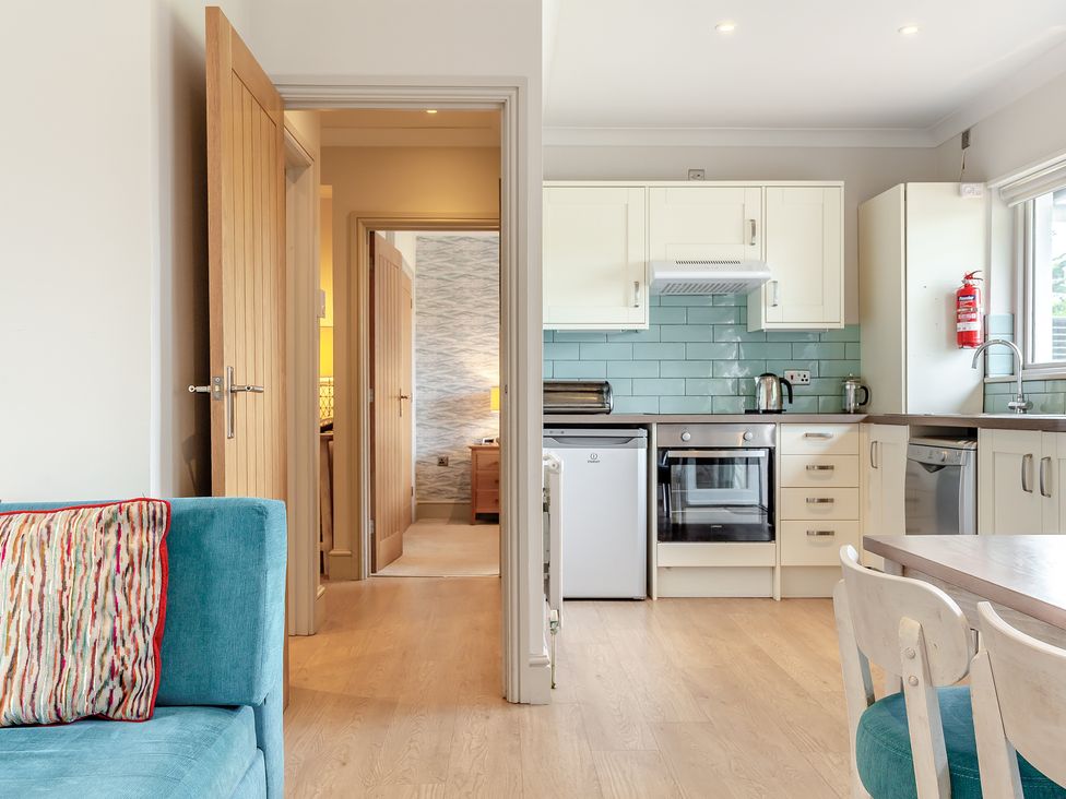 A kitchen with a dining table and sofa at 4C2 Summerleaze Garden Cottage 2 Spa Bude