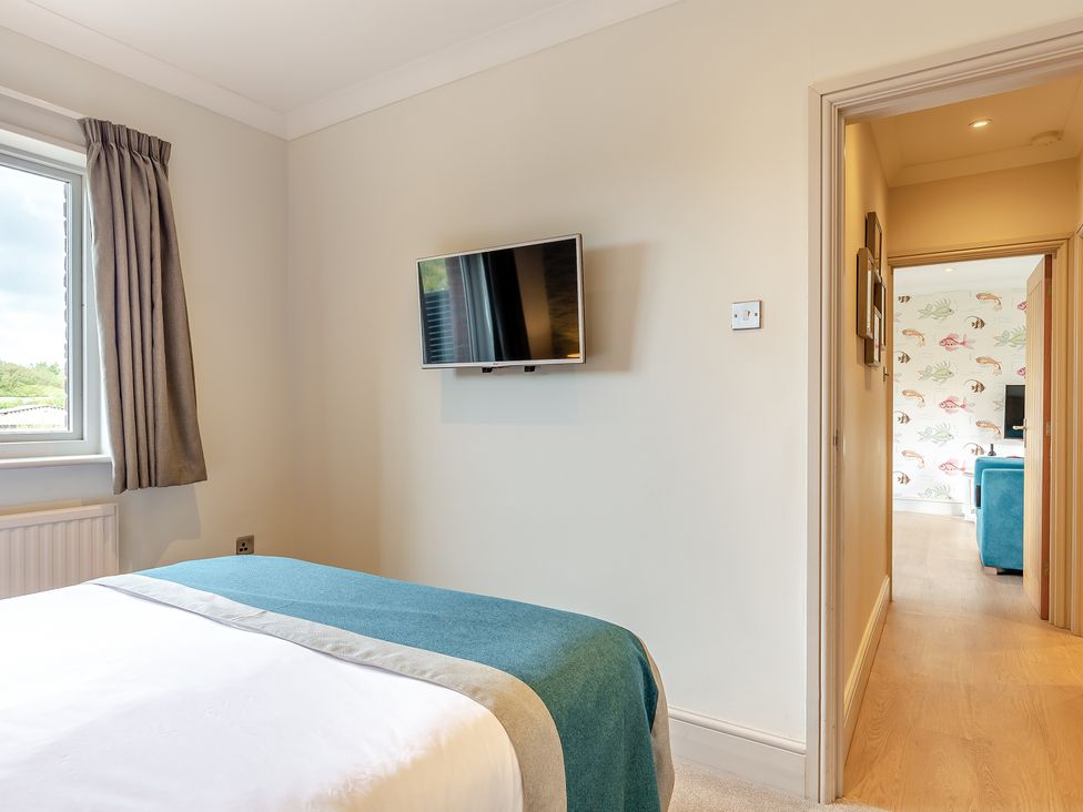 A bedroom with a bed and a television at 4C2 Summerleaze Garden Cottage 2 Spa in Bude