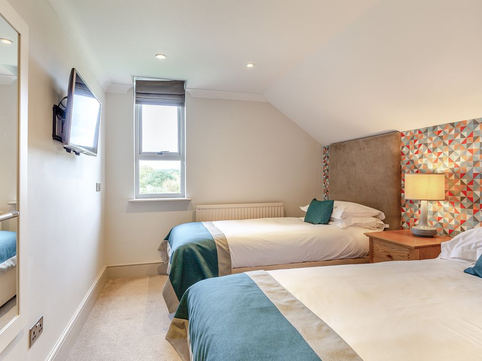 A bedroom with two beds and a television at 4C2 Summerleaze Garden Cottage 2 Spa in Bude