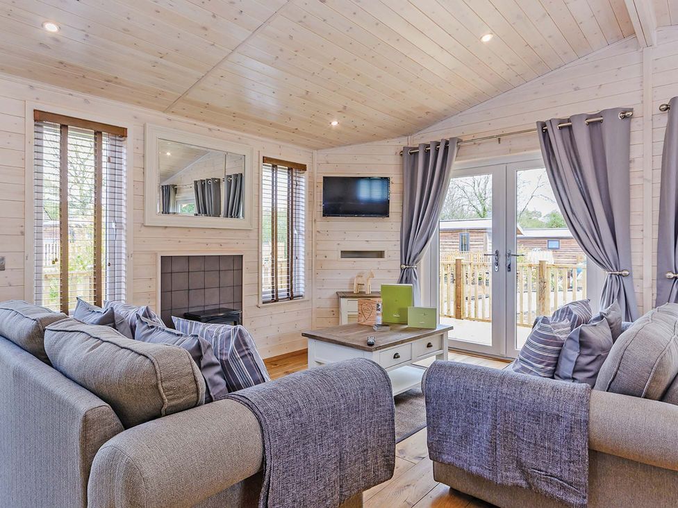 A living room with a sofa and television at Hurricane Lodge in Fair Oak