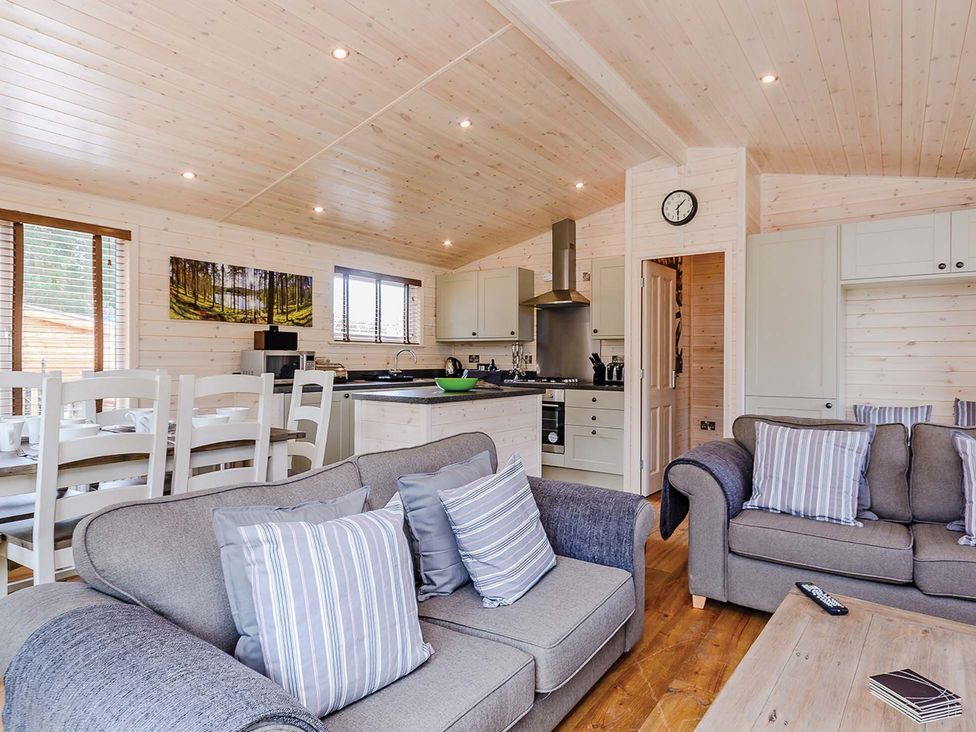 A living room with a kitchen area and seating at Hurricane Lodge in Fair Oak