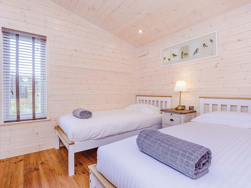 A bedroom with two beds and a bedside table at Hurricane Lodge Fair Oak