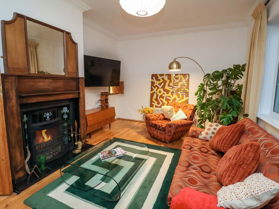 A living room with a sofa, armchair, and coffee table at The White House in Norwich