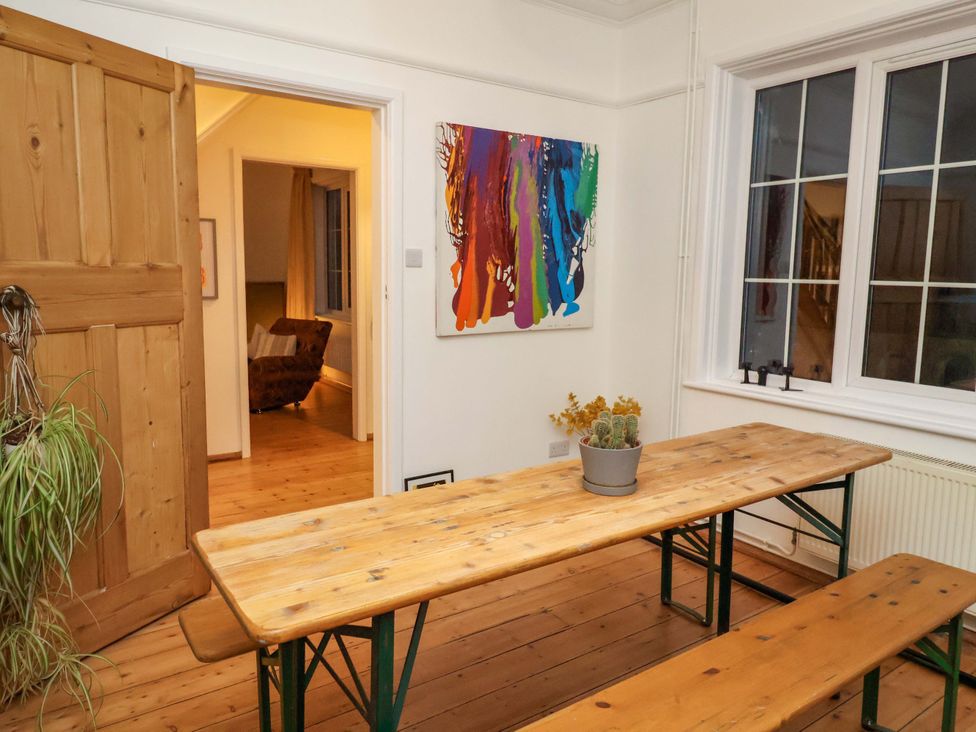 A dining room with a wooden table and benches at The White House in Norwich