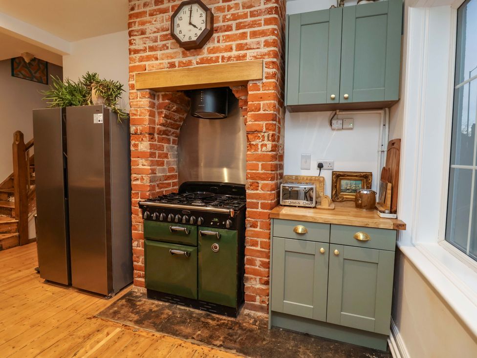 A kitchen with a refrigerator and oven at The White House in Norwich