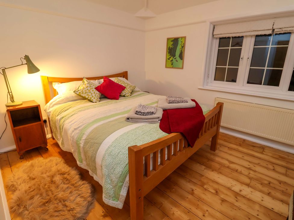A bedroom with a bed, bedside table, and lamp at The White House in Norwich