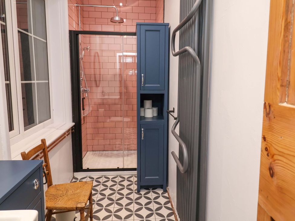 A bathroom with a shower and storage cabinet at The White House in Norwich
