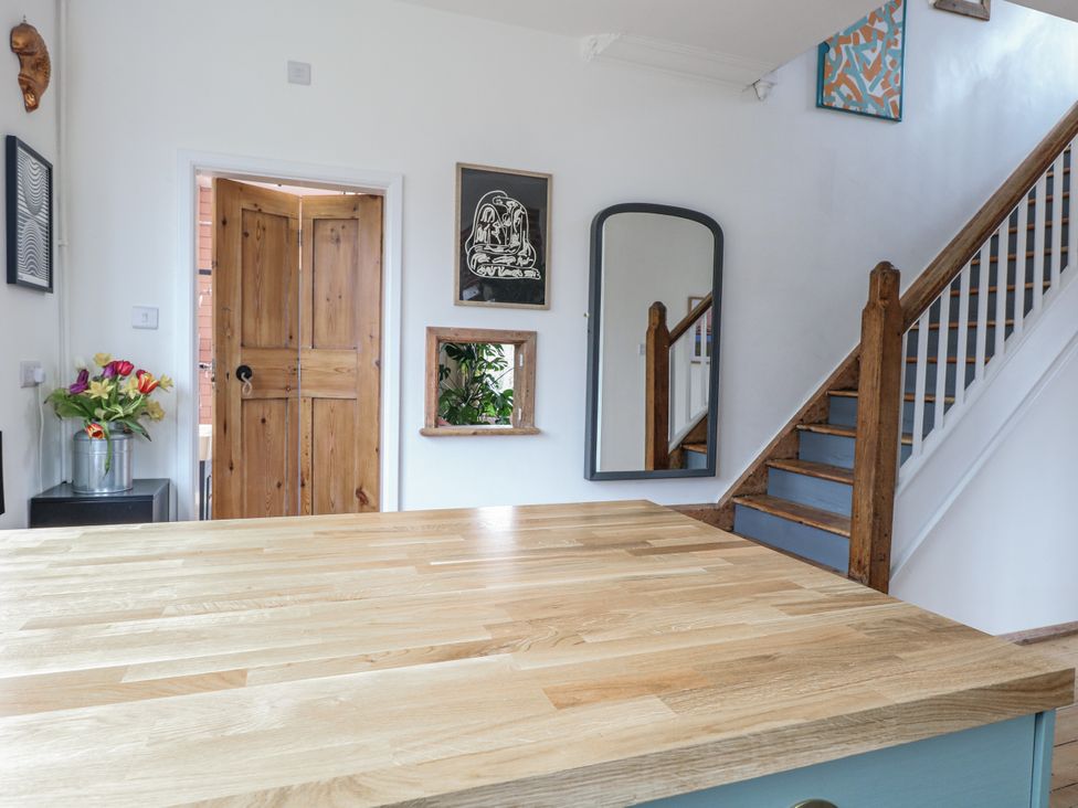 A kitchen with a table and a door at The White House in Bracondale