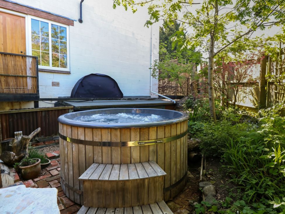 A garden featuring a hot tub and plants at The White House in Bracondale