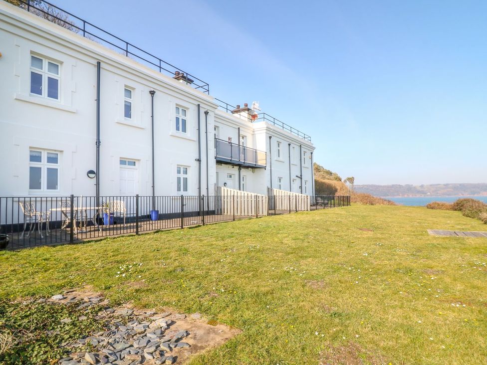 A building with a fenced outdoor area and grass at The Old Signal House in Torpoint