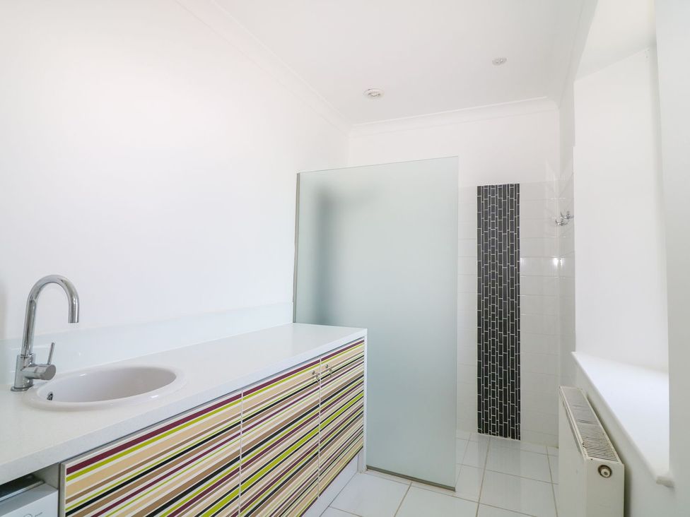 A bathroom with a cabinet and shower area at The Old Signal House in Torpoint