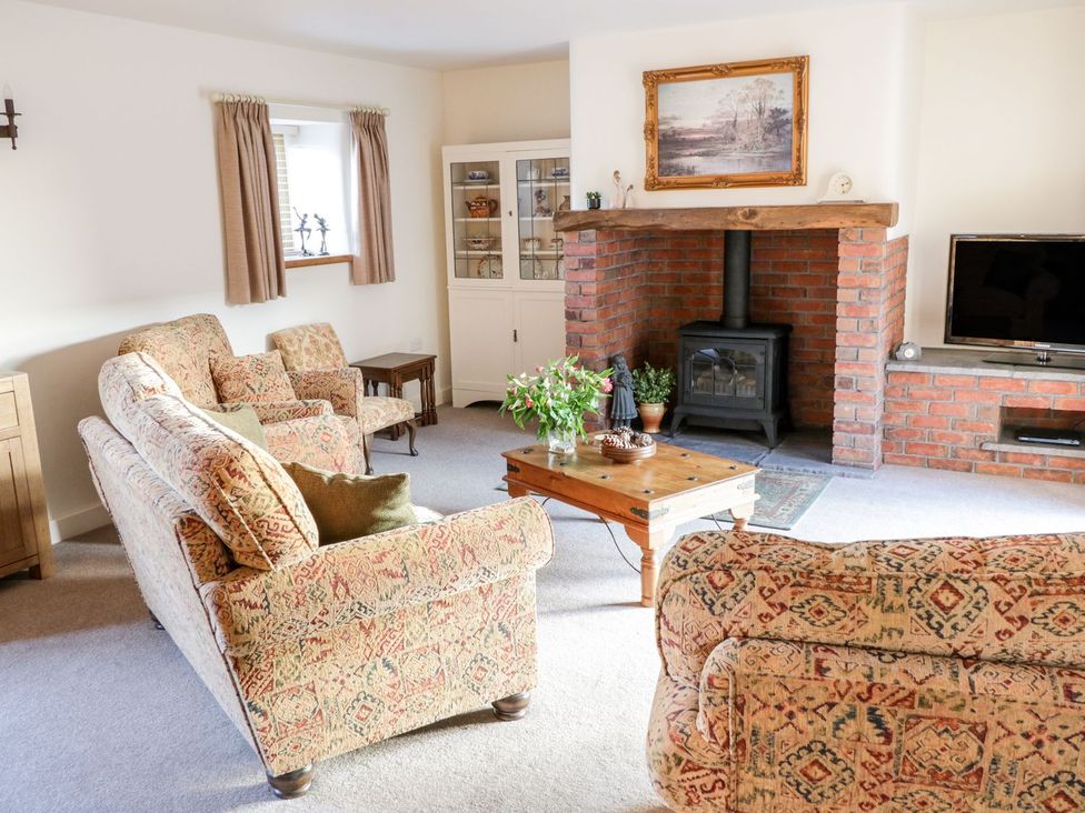 A living room with a fireplace and furniture at Grange Cottage in Crediton