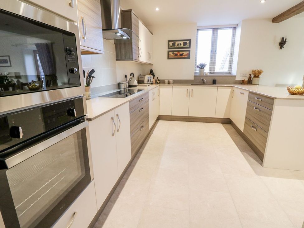 A kitchen with appliances and cabinets at Grange Cottage in Crediton