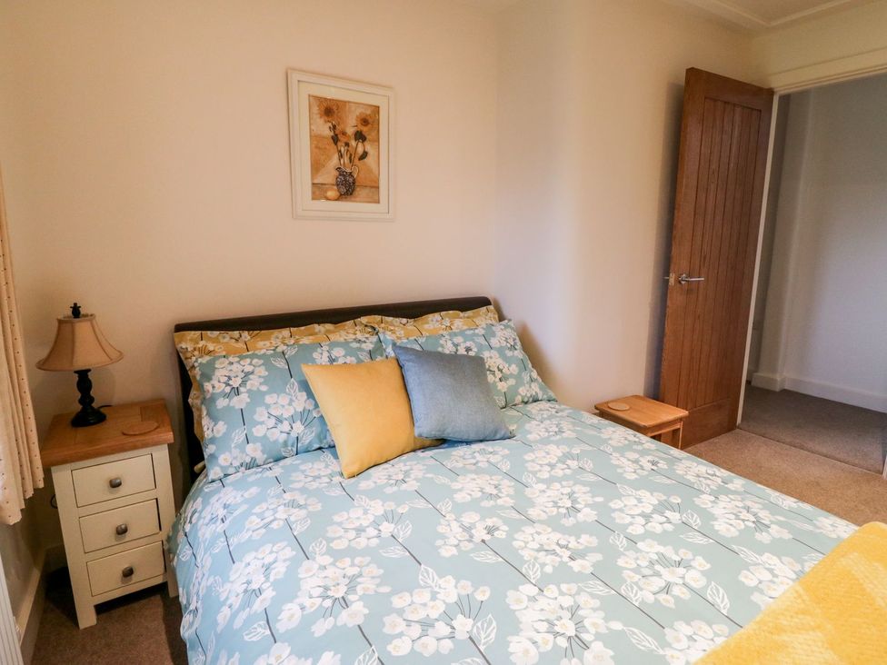 A bedroom with a bed and bedside table at Grange Cottage in Crediton