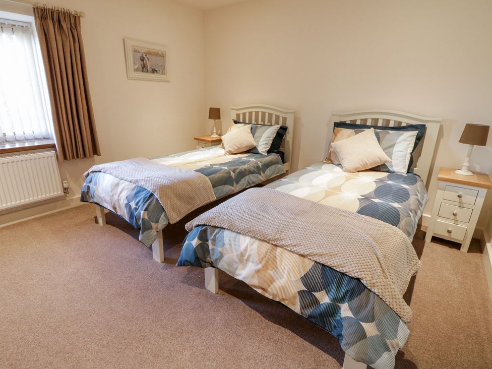 A bedroom with two single beds and a bedside table at Grange Cottage in Crediton