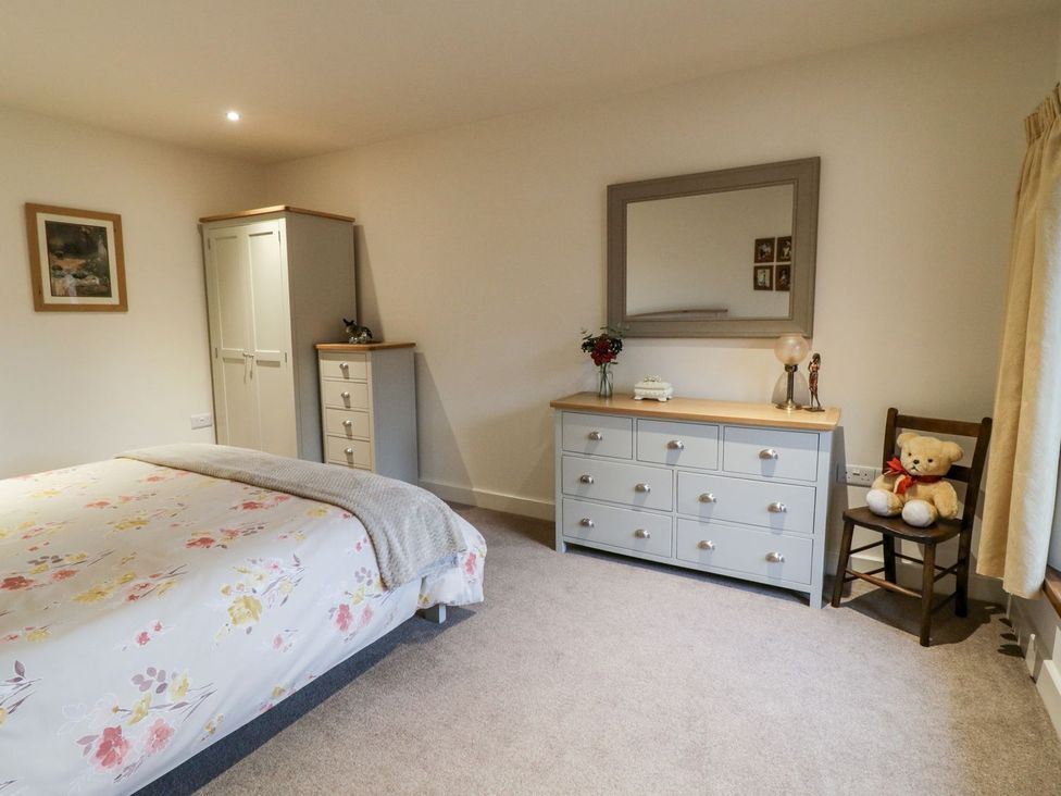 A bedroom with a bed and dresser at Grange Cottage in Crediton
