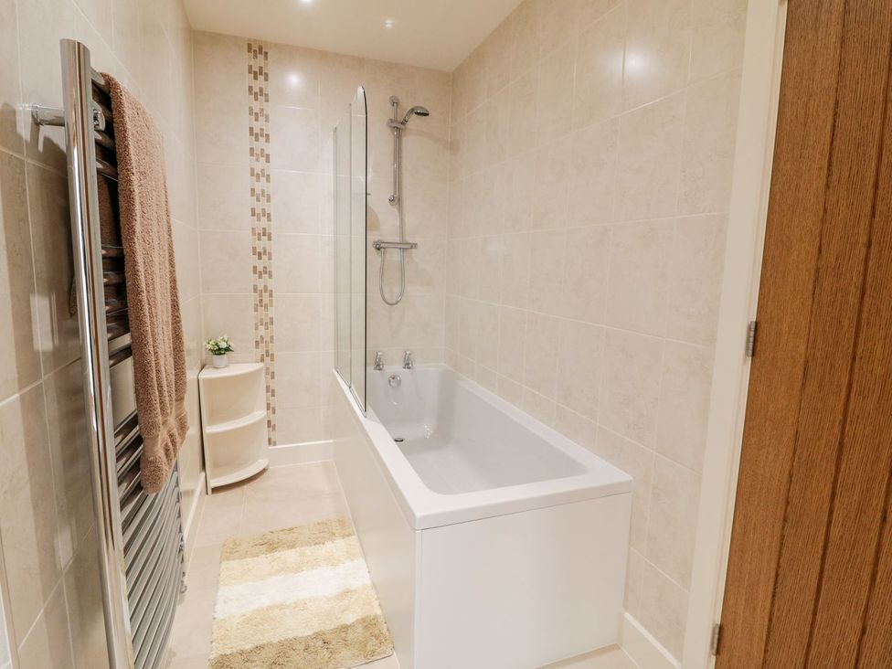 A bathroom with a bathtub and shower at Grange Cottage in Crediton