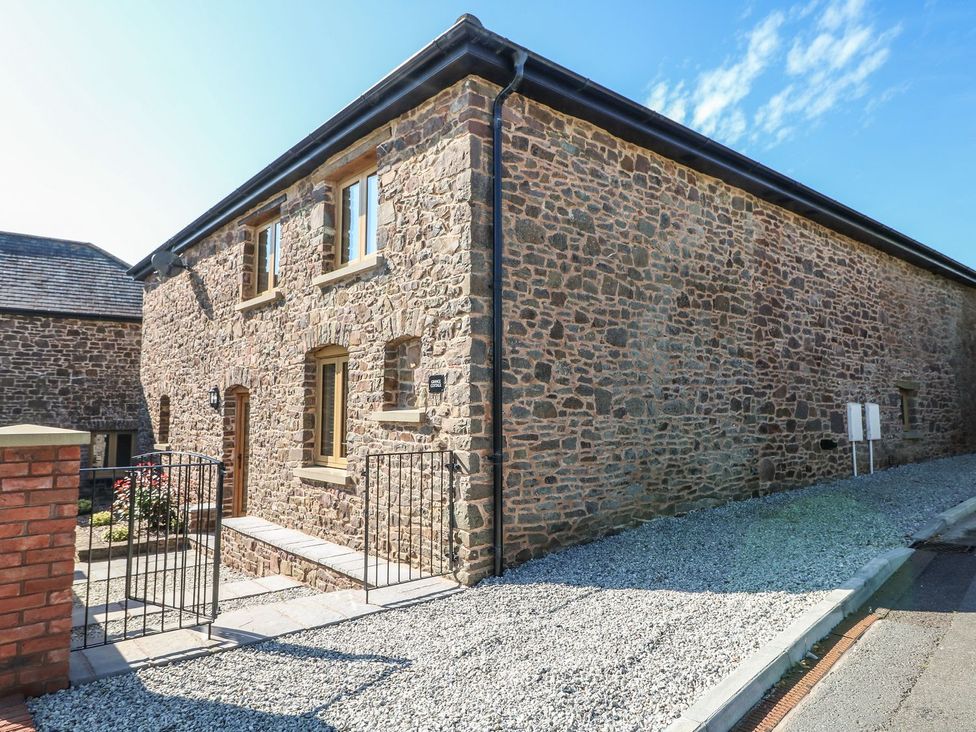 A stone building with windows and a door at Grange Cottage in Crediton